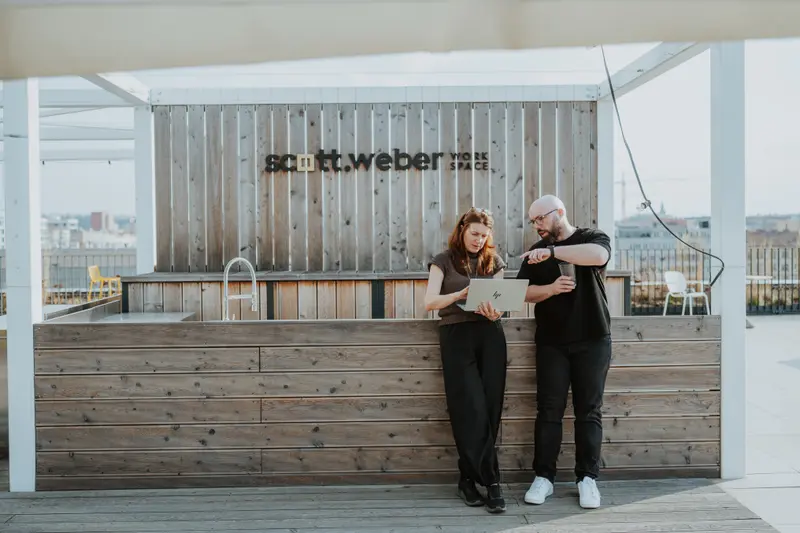 Freelancer a konzultant u notebooku na terase s výhledem na město